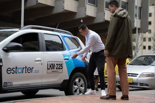 Conductor de Estarter.co atendiendo a pasajero junto a camioneta Renault Duster